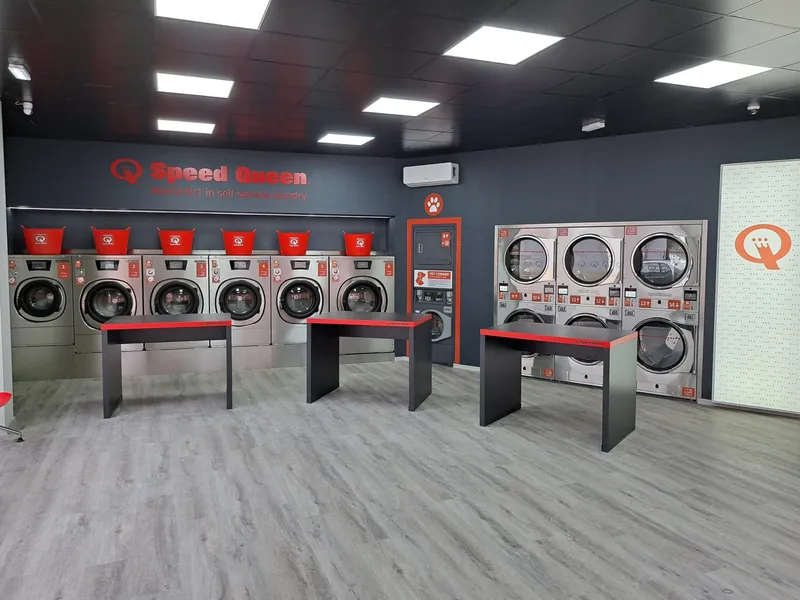 Sala de lavado, con lavadoras Speed Queen y mesas de plegado · Lavandería Gira Gira en San Fernando de Henares