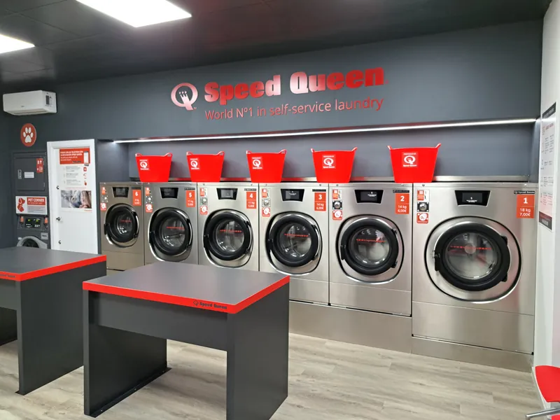 Sala de lavado, con lavadoras Speed Queen y mesas de plegado · Lavandería Gira Gira en Torrejón de Ardoz